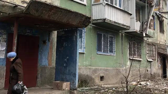 La anciana Alexandra sale de su casa en Kostiantynivka a dejar la basura