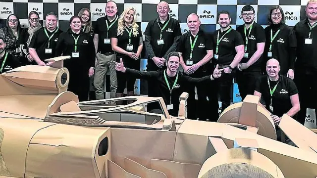 Trabajadores de Saica posan con el Fórmula 1 de cartón en Newport (Gales), en el Reino Unido.
