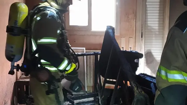Los bomberos, en el interior de la vivienda afectada.