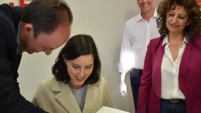 Andrea Fernández firma en el libro de honor del PSOE de Calatayud acompañada de Víctor Ruiz y Sandra Marín.