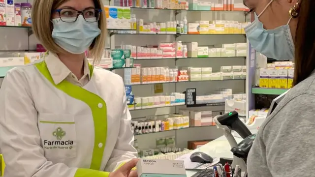 La farmacéutica Margot Roig dispensa un suplemento vitamínico a una zaragozana.