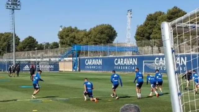Alberto Zapater, rodilla en tierra, con botas naranjas, en el entrenamiento de este jueves en la Ciudad Deportiva tras conocerse su adiós al Real Zaragoza.