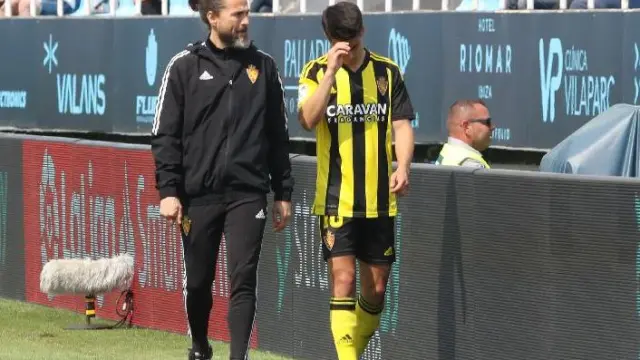 Sergio Bermejo se retira lesionado y preocupado del partido Ibiza-Real Zaragoza, el pasado día 20, acompañado por el fisio Jesús Dueñas.