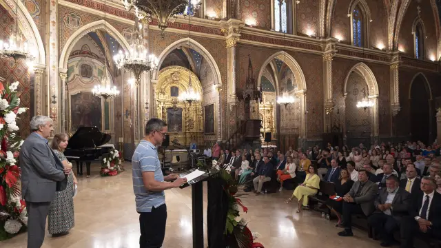 Un usuario de Atadi lee el pregón de las fiestas en una iglesia de San Pedro repleta de público.