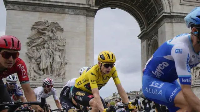 El maillot amarillo del Tour de Francia, el ciclista danés Jonas Vingegaard, pasa con el pelotón delante del Arco del Triunfo en París