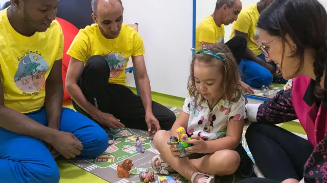 Mohamed, Brahim y Beatriz Pérez juegan con una niña con diversidad funcional.