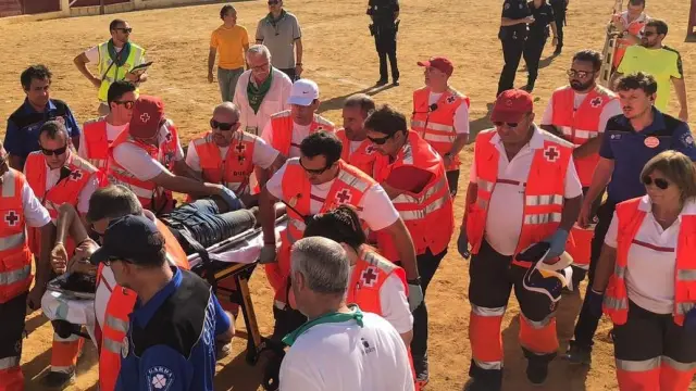 Voluntarios de Cruz Roja atendiendo a un joven lesionado en las vaquillas de Huesca.