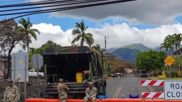 Tres militares vigilan uno de los accesos cerrados a la capital de la isla de Maui.