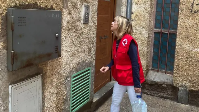 Una voluntaria de Cruz Roja lleva una garrafa de agua embotellada a un domicilio de Tarazona.