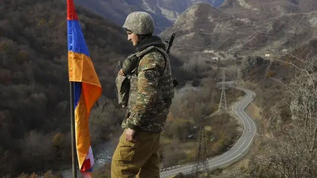 Un soldado de origen armenio, junto a una bandera de Nagorno Karabaj.