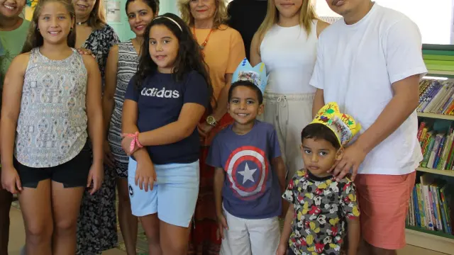 Las dos últimas familias en instalarse en Pallaruelo de Monegros, junto a sus hijos, posan con el resto de escolares, su profesor y varios vecinos.