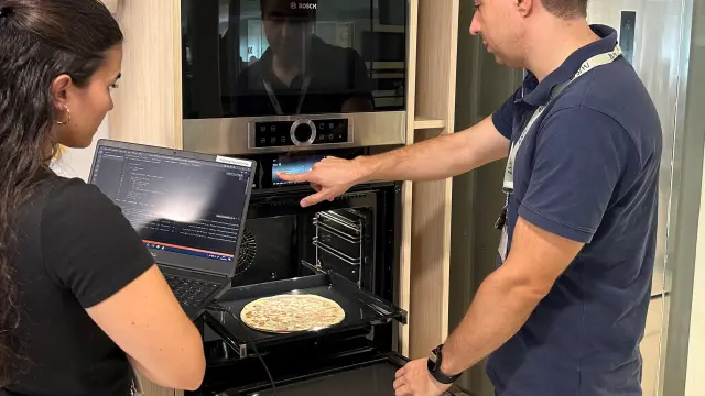 Mar Lahoz y Héctor Martínez, ingenieros de BSH, colocan una pizza para probar el horno.