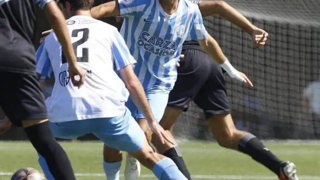 Un jugador del Racing Club Zaragoza recupera la posesión y evita que le roben el balón dos jugadores del Constancia.