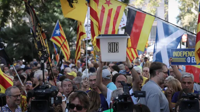 Varias personas conmemoran el aniversario del referéndum del 1-O, en la plaza de Urquinaona, en Barcelona.