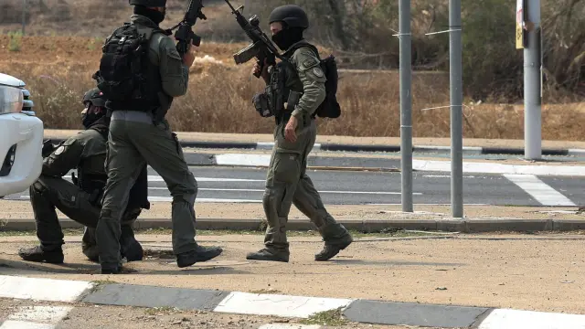 Israeli security take position as a car approaches on a road following a mass infiltration by Hamas gunmen from the Gaza Strip, near Sderot in southern Israel October 8, 2023. REUTERS/Ronen Zvulun ISRAEL-PALESTINIANS/