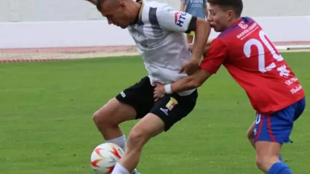 Un jugador del Calatayud disputa un balón ante la presión del Mallén