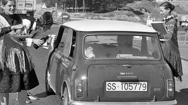 Varios jóvenes agasajan a un turista con jamón y vino a la entrada de Teruel, en una foto de la década de 1970.