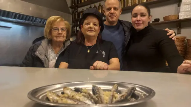 La familia que lo regenta, con sus típicas sardinas sobre la mesa.