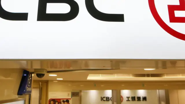 FILE - Bank tellers sit in a branch office of the Industrial and Commercial Bank of China (ICBC) in Hong Kong on March 27, 2013. A financial services business of China’s biggest bank says it was hit by a ransomware attack that reportedly disrupted trading in the U.S. Treasury market. (AP Photo/Kin Cheung, File)