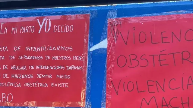 Pancartas anónimas adheridas en la pared del Hospital Materno-Infantil-Hospital Universitario Miguel Servet de Zaragoza.