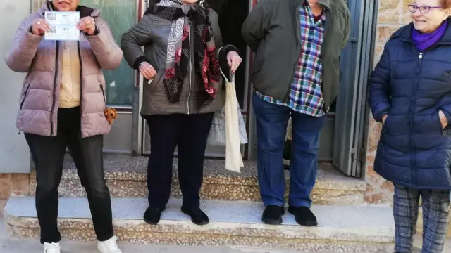 Manoli Burgos y varias integrantes de la Asociación de Mujeres Progresistas de Alhama de Aragón celebran en sus calles el quinto premio