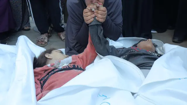 La madre palestina Asmaa Naser llora los cuerpos de sus hijos gemelos asesinados como resultado de un ataque aéreo israelí contra el campo de Nuseirat