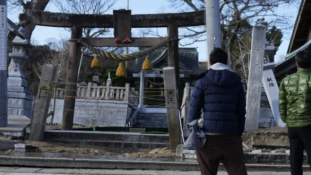 Dos personas miran casas derruidas por el seísmo en Kohoku.