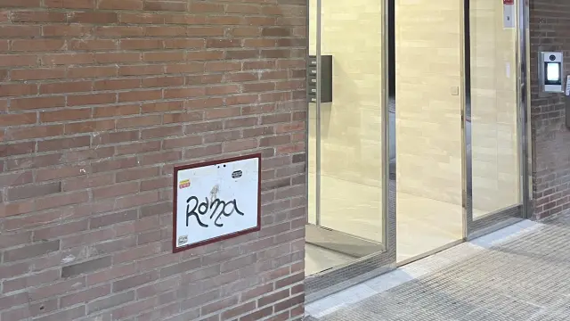 Un portal de Zaragoza, con una puerta automática que puede abrirse con una chapita.