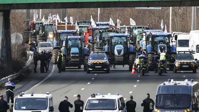 Agentes de policía vigilan decenas de tractores que participan en una manifestación en la autopista A15 cerca de Argenteuil, al norte de París