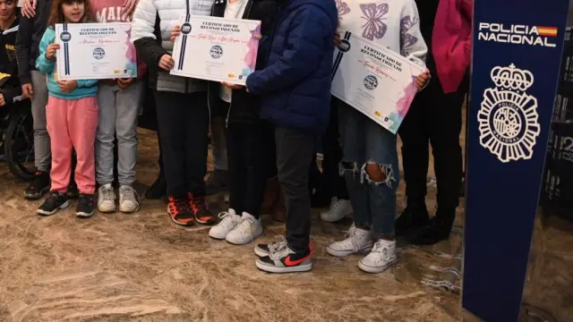 Foto de familia de las autoridades de Huesca con los escolares premiados en el concurso de dibujo de la Policía Nacional.