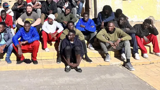 Un grupo de migrantes subsaharianos alojados temporalmente en el albergue de Pirerarium, de Sabiñánigo, junto a un miembro de la Plataforma Pro Refugiados Alto Aragón.