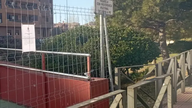 La pasarela del río Isuela que conecta con el Hospital Provincial de Huesca lleva un año cerrada por motivos de seguridad esperando su rehabilitación.