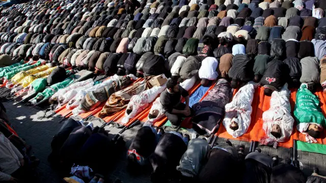 Numerosos palestinos rezan junto a los cuerpos de los 43 palestinos asesinados en un ataque israelí