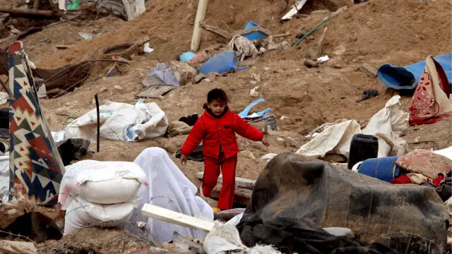 Una niña se dirige al colegio entre los escombros de la guerra