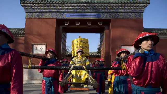 Varios actores vestidos con trajes típicos participan en la representación de un sacrificio imperial en el Parque Ditan de Pekín