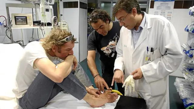 Javier Pérez (izquierda), Carlos Pauner (centro) y el cirujano Ismael Gil Romea, del Clínico, observan los dedos dañados del zaragozano.