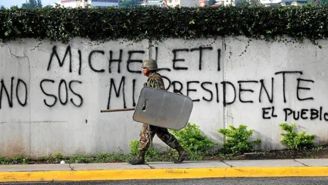 Un soldado pasa ante una pintada contra Roberto Micheletti en los alrededores del palacio presidencial, en Tegucigalpa.