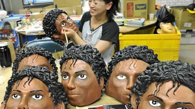 Una artesana japonesa decora unas caretas de goma con la efigie de Michael Jackson.