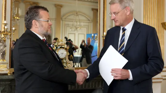 El ministro de Asuntos Exteriores islandés, Ossur Skarphedinsson (i) estrecha la mano de su homólogo sueco, Carl Bildt (d)