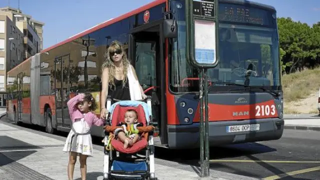 Pilar con su hija Lorena y su hermano pequeño, ayer en la parada del bus 23 en La Paz.