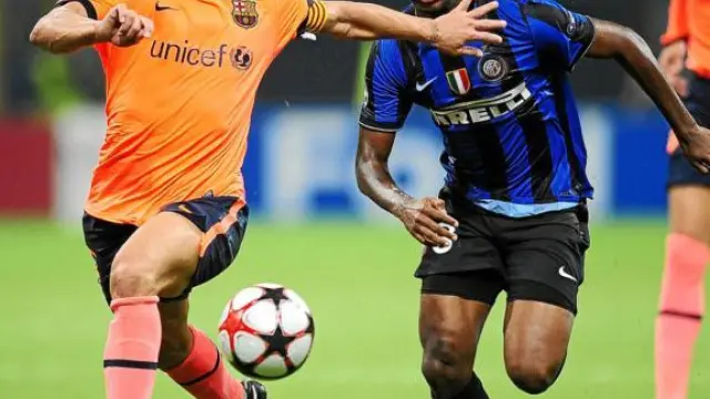 Samuel Eto'o trata de superar a Carles Puyol en el duelo de ayer en Milán.