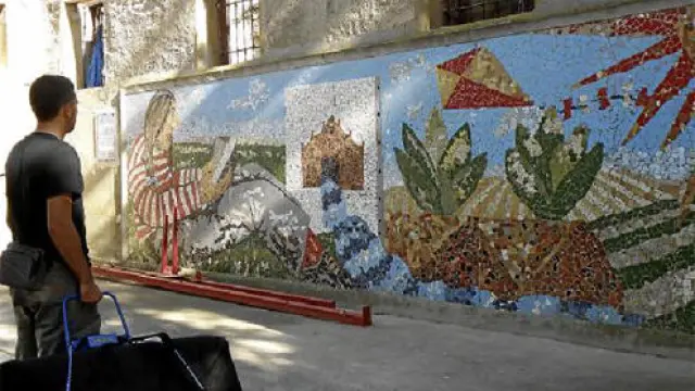 Un vecino contempla el mural de Ignacio Fortún, situado en un edificio abandonado.
