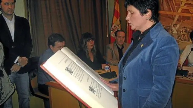 La socialista Vicente jurando su cargo como alcaldesa de Alcorisa ante la mirada de Burriel, al fondo.
