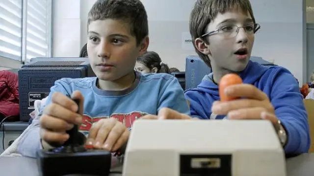 Dos niños juegan con uno de los Atari ST instalados en el aula de simuladores de Retromañía 2009.