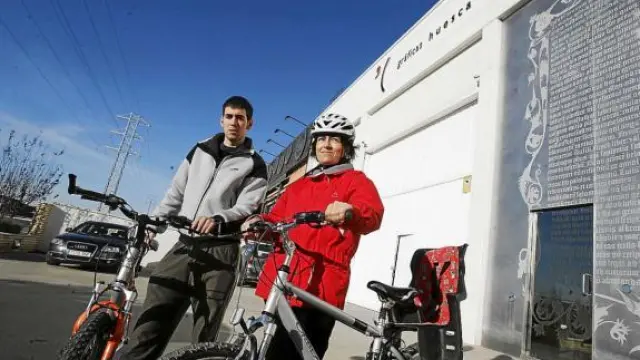 Adrián Inglada y Silvia Perbech, con sus bicicletas delante de la empresa Gráficas Huesca