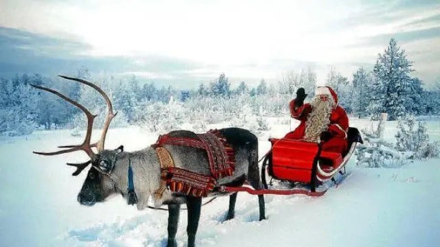 Una foto de Papá Noel en su trineo, en la nieve de Laponia, al norte de Finlandia