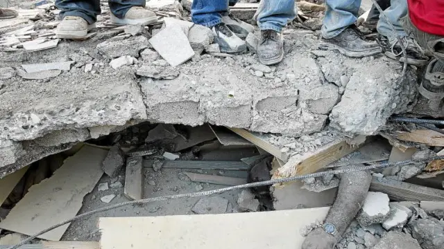 El brazo de un hombre sepultado aparece bajo los escombros de una construcción en Puerto Príncipe.