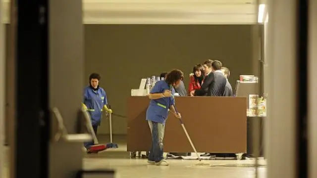 Personal de limpieza contratado para un espectáculo limpia un charco en el Palacio de Congresos.