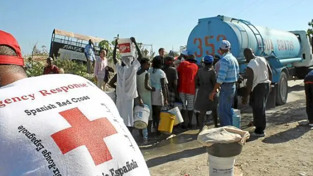 Miembros de Cruz Roja Española supervisan la distribución de agua potable en Puerto Príncipe.