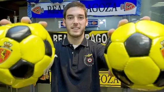 Pablo Alcolea suejeta dos miniaturas de balón en la tienda del Real Zaragoza.